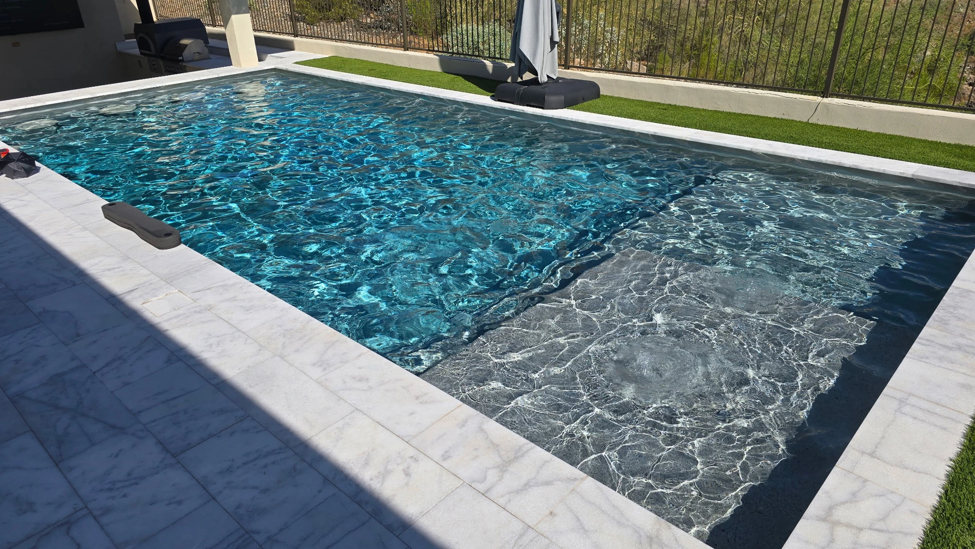 Clear blue residential pool receiving weekly pool service